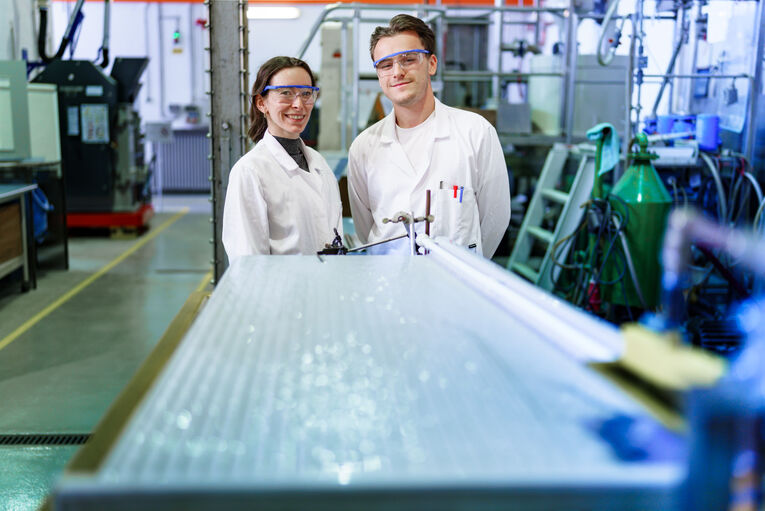 Studierende der THGA stehen am Rütteltisch, dort wird ein Sand Mikroplastikgemisch getrennt.