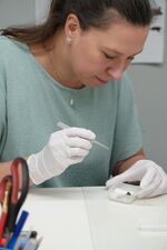 Annika Lüttmann bei der Untersuchung einer Fibel