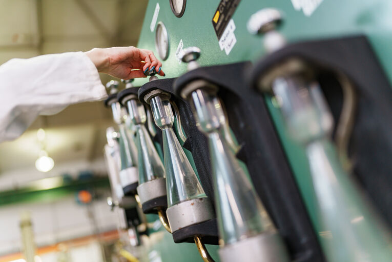 Hand an einem Laborgerät mit mehreren Kolben, Laboruntersuchung für die Verfahrenstechnik