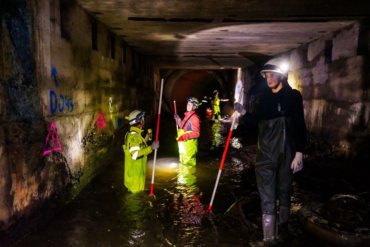 Zu sehen sind drei Wissenschaftler, davon einer mit einem Messgerät im Vordergrund. Sie vermessen und prüfen die Bausubstanz des Passbachtunnels im Ruhrgebiet. 